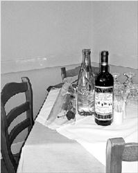 Ένα μπουκάλι κρασί, ένα μπουκάλι  νερό (όπως συνήθιζε) και ένα  τριαντάφυλλο στο μόνιμο τραπέζι  του Γιάννη Μόραλη, χτες, στην  ταβέρνα του Φιλίππου- φωτογραφία  από τον Γιώργο Βέλτσο  