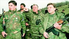 Εναν χρόνο προτού εκδοθεί το διεθνές ένταλµα εις βάρος του, στις 16 Απριλίου του 1994, ο τότε στρατιωτικός ηγέτης των Σερβοβοσνίων, Ράτκο  Μλάντιτς, δείχνει κάτι στους σωµατοφύλακές του, στο Γκόραζντε της Ανατολικής Βοσνίας  