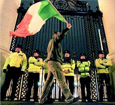 Διαδηλωτής ανεµίζει την ιρλανδική σηµαία έξω από το υπουργείο Οικονοµικών χθες στο Δουβλίνο. Χθες η Ιρλανδία  έγινε η δεύτερη ευρωπαϊκή χώρα που προσέφυγε στον µηχανισµό στήριξης της Ε.Ε. της ΕΚΤ και του ΔΝΤ  