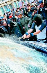 Ενας διαδηλωτής σπάει το τζάµι ενός αυτοκινήτου της Αστυνοµίας, κατά τα  επεισόδια που σηµάδεψαν τη χθεσινή φοιτητική διαδήλωση στο Λονδίνο  