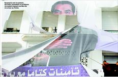 Κρεµασµένοι από ένα µπαλκόνι,  δύο άνδρες προσπαθούν να κατεβάσουν  ένα σχισµένο πορτρέτο του Μπεν Αλι  στο κέντρο της Τύνιδας  