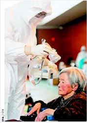 Ειδικός επιστήµονας µετράει  τα επίπεδα ραδιενέργειας  σε 
ηλικιωµένη γυναίκα από  την περιοχή της Φουκουσίµα  