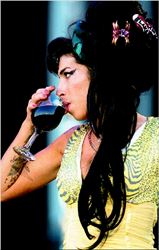 Η Εϊµι Γουάινχαουζ, σε φωτογραφία από  συναυλία του 2008 στη Μαδρίτη, ξεδιψάει  µε... κόκκινο κρασί πάνω στη σκηνή  